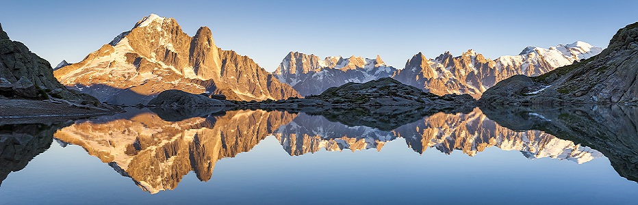 Panorama of Alps mountain range, sunset lights, reflection in lake